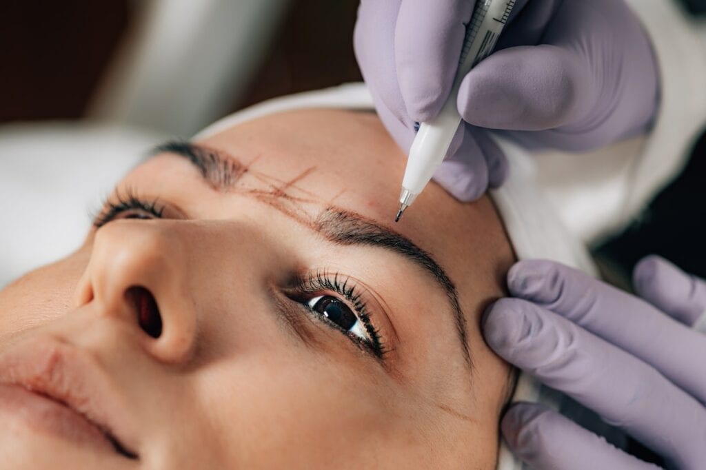 Close-up of Beautician Doing Permanent Microblading Eyebrow Tattoo