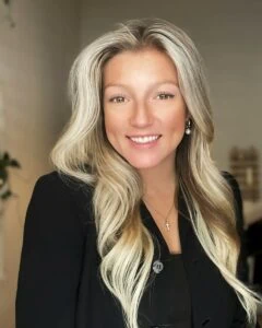 Josephine Ray, salon coordinator Oviedo - Female with long blonde hair and a black hat, standing with her dog.